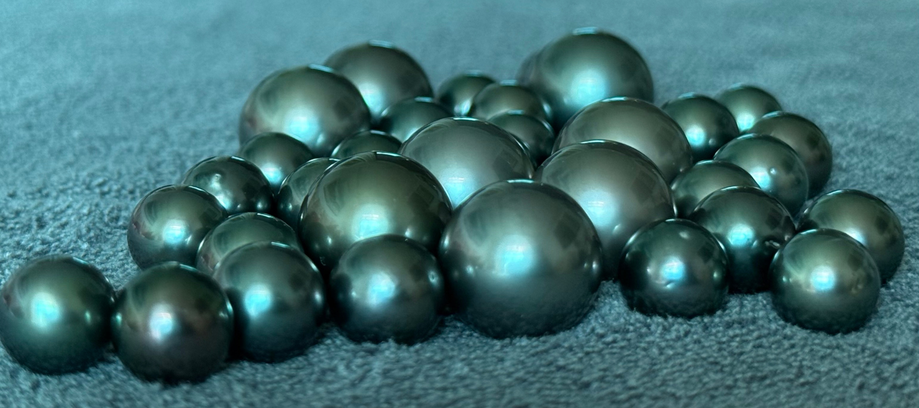 Tahitian pearls from Totapari, showing the dark body colour and the internal glow that distinguishes a pearl from a cut stone.
